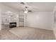 Spacious living room with carpet flooring, ceiling fan, fireplace, and decorative shelves at 9048 Faversham Ct, Las Vegas, NV 89123