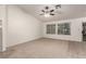Cozy living room featuring neutral carpet, bright windows, and a ceiling fan at 9048 Faversham Ct, Las Vegas, NV 89123