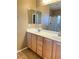 Bathroom with double sinks, wood cabinets, and a glass-enclosed shower for a spa-like experience at 10349 Mystic Pine Rd, Las Vegas, NV 89135