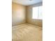 A bright bedroom featuring neutral walls, plush carpet, and a sun-filled window at 10349 Mystic Pine Rd, Las Vegas, NV 89135