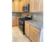 A view of the kitchen features a stainless steel oven, granite countertops, and wood cabinets at 10349 Mystic Pine Rd, Las Vegas, NV 89135