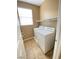 Bright laundry room with a large window, white washer and dryer, and ample shelving space at 10349 Mystic Pine Rd, Las Vegas, NV 89135