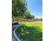 Expansive community park with lush green lawns, playground, and walking paths beneath a clear blue sky at 10349 Mystic Pine Rd, Las Vegas, NV 89135