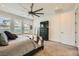 Main bedroom features a ceiling fan, large window, and stylish dark wood dresser at 10456 Skye Arroyo Ave, Las Vegas, NV 89166