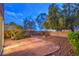 Spacious backyard featuring a stone patio, mature trees, and rock landscaping at 11178 Corsica Mist Ave, Las Vegas, NV 89135
