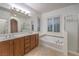 Bathroom featuring a soaking tub, glass-enclosed shower, and dual sinks at 11178 Corsica Mist Ave, Las Vegas, NV 89135