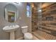 Bathroom featuring a pedestal sink, toilet, and tiled walk-in shower with a glass door at 11178 Corsica Mist Ave, Las Vegas, NV 89135