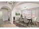 Bright, virtually staged dining room featuring tile flooring, an arched doorway, and stylish seating for elegant gatherings at 11178 Corsica Mist Ave, Las Vegas, NV 89135