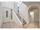 Bright foyer featuring a staircase, arched doorway, and tile flooring at 11178 Corsica Mist Ave, Las Vegas, NV 89135