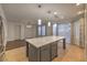 Kitchen with stainless steel appliances, center island with seating, tile floors, and modern pendant lighting at 11178 Corsica Mist Ave, Las Vegas, NV 89135