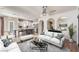 Bright, open-concept, virtually staged living room with an open kitchen, white furniture, and elegant finishes at 11178 Corsica Mist Ave, Las Vegas, NV 89135