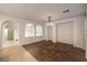 Open living room with hardwood flooring, arched doorways, and view of the kitchen at 11178 Corsica Mist Ave, Las Vegas, NV 89135