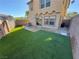 Backyard featuring artificial turf, patio, and sliding glass door access to the home at 1155 Paradise Safari Dr, Henderson, NV 89002