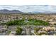 Scenic aerial view of a community featuring a park with mature trees, and beautiful mountain views at 11732 Del Sur Ave, Las Vegas, NV 89138