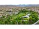 Wide aerial view of a community with a clock tower, playground, trees, and lush landscaping at 11732 Del Sur Ave, Las Vegas, NV 89138