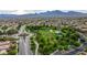 Expansive aerial view showcasing a community park with a clock tower, greenery, and residential homes at 11732 Del Sur Ave, Las Vegas, NV 89138