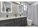 Elegant bathroom features gray cabinets, dual sinks, framed mirrors and gray marble backsplash at 11732 Del Sur Ave, Las Vegas, NV 89138