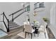 Bright dining room with modern chandelier, grand staircase and seating for six at 11732 Del Sur Ave, Las Vegas, NV 89138