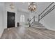Stately foyer with hardwood floors, grand staircase, and modern lighting at 11732 Del Sur Ave, Las Vegas, NV 89138