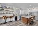 Modern kitchen features a central island with seating, stainless steel appliances, light countertops and custom cabinetry at 11732 Del Sur Ave, Las Vegas, NV 89138