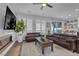 Well-lit living room featuring a modern fireplace, mounted television, plantation shutters, stylish area rug, and a ceiling fan at 11732 Del Sur Ave, Las Vegas, NV 89138