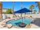 Resort-style backyard oasis featuring a pool with a built-in bar, waterfall, and lush palm trees at 11732 Del Sur Ave, Las Vegas, NV 89138
