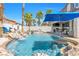 Outdoor oasis featuring a custom pool with a waterfall, swim-up bar, outdoor kitchen, and palm trees at 11732 Del Sur Ave, Las Vegas, NV 89138