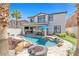 An outdoor kitchen and lush landscaping surround this beautiful pool with a waterfall and dining at 11732 Del Sur Ave, Las Vegas, NV 89138