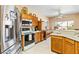 Bright kitchen with stainless steel appliances, wood cabinetry, and tiled floors for easy maintenance at 1204 Golf Club, Laughlin, NV 89029