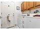 Functional laundry room with washer, dryer, and storage cabinets near an exterior door at 1204 Golf Club, Laughlin, NV 89029