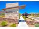 Elegant Castellana entry monument with desert landscaping and a well-maintained sidewalk at 12101 Arrebol Ave, Las Vegas, NV 89138