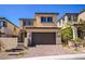 Two-story home featuring a neutral color palette, desert landscaping, and a brick driveway at 12101 Arrebol Ave, Las Vegas, NV 89138