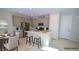 Staged kitchen with stainless appliances, island with seating, and gray cabinets at 12101 Arrebol Ave, Las Vegas, NV 89138