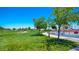Expansive park area with green grass and shady trees, next to playground at 12101 Arrebol Ave, Las Vegas, NV 89138