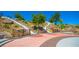 A playground is built into a hillside, offering a unique play experience with dual slides and terraced landscaping at 12101 Arrebol Ave, Las Vegas, NV 89138