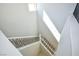 Bright, carpeted staircase with modern metal railing bathed in natural light from a high window at 12101 Arrebol Ave, Las Vegas, NV 89138