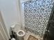 Bathroom with toilet and shower featuring palm tree shower curtain at 1288 Ventura Cliffs Ave, Henderson, NV 89012