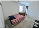 Simple bedroom with minimal furnishings and a checkered bedspread, bathed in natural light at 1288 Ventura Cliffs Ave, Henderson, NV 89012