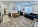 Well-lit bedroom featuring modern decor, laminate flooring, and a comfortable seating area at 1288 Ventura Cliffs Ave, Henderson, NV 89012
