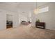 Open living room featuring neutral carpet, chandelier, and an adjacent laundry room at 1470 St Joseph St, Overton, NV 89040