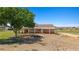 Large home with covered porch and spacious yard with mature trees and blue sky at 1470 St Joseph St, Overton, NV 89040