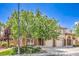 Inviting two-story home with lush green lawn and a mature shade tree covering the two-car garage at 1605 Colloquium Dr, Henderson, NV 89014