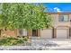 Charming townhouse with a well-manicured lawn, a mature shade tree, and a two-car garage at 1605 Colloquium Dr, Henderson, NV 89014