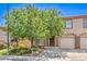 Attractive townhouse with a manicured lawn, mature shade tree, and an attached single car garage at 1605 Colloquium Dr, Henderson, NV 89014