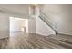 Spacious living room featuring laminate flooring, a white staircase, and a glimpse of the landing above at 1605 Colloquium Dr, Henderson, NV 89014