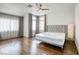 This bedroom features hardwood floors, a ceiling fan, and natural light from the windows at 1793 Clear River Falls Ln, Henderson, NV 89012