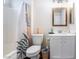Bright bathroom featuring a vanity with a wood-framed mirror, toilet, and a shower-tub combo at 1808 Quartz Landing Ave, Las Vegas, NV 89183