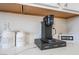 Coffee bar area with a coffee maker, coffee and sugar containers, and white marble countertops at 1808 Quartz Landing Ave, Las Vegas, NV 89183