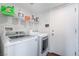 Clean laundry room featuring a washer, dryer, shelving, and a neutral painted door at 1808 Quartz Landing Ave, Las Vegas, NV 89183