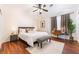 Comfortable bedroom featuring a ceiling fan, wood floors, and a well-lit workspace near the window at 1808 Quartz Landing Ave, Las Vegas, NV 89183